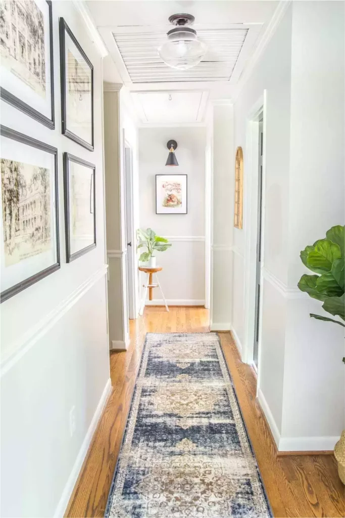 Hallway wall gallery of architectural sketches above a patterned runner