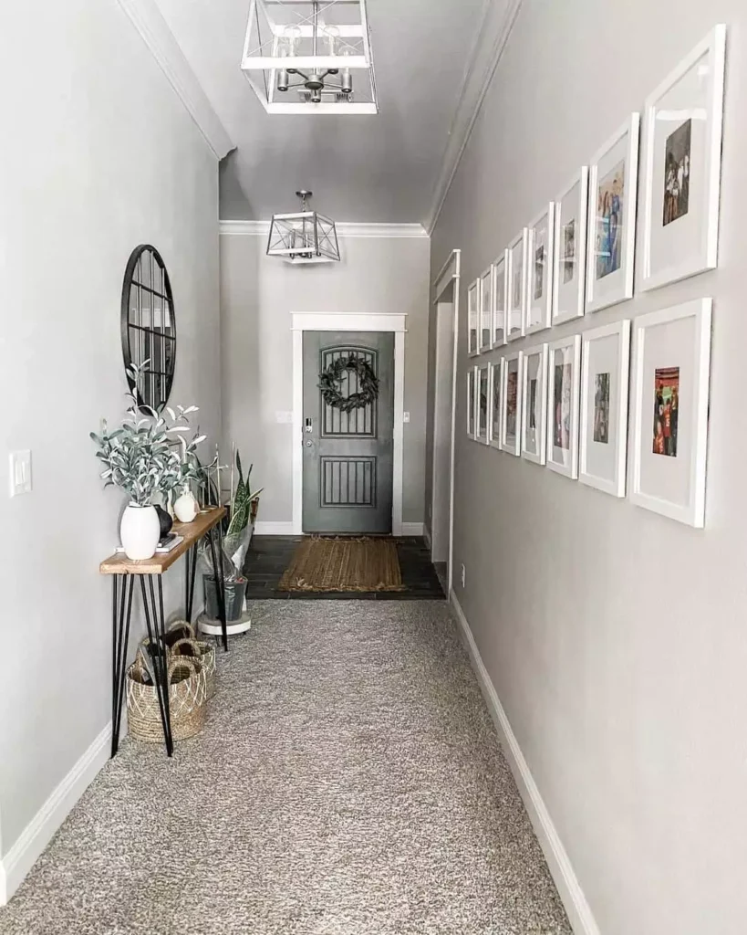 Hallway wall lined with a large white framed photo gallery grid