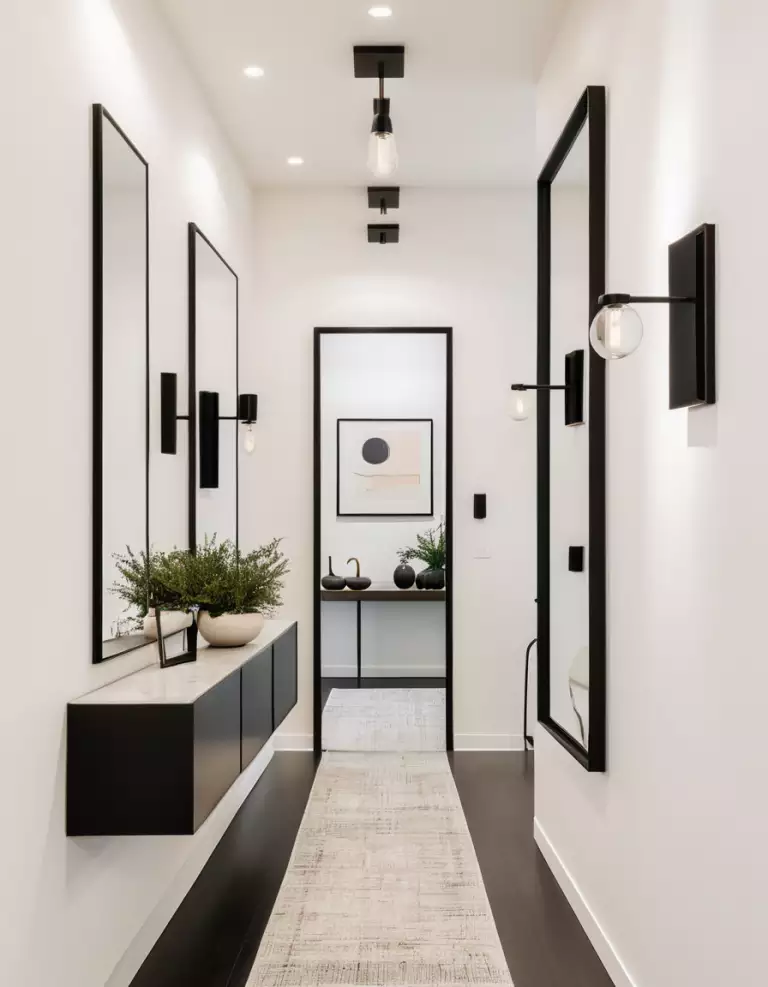 Hallway wall lined with black framed mirrors above a floating black console