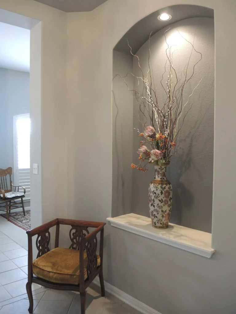 Hallway wall niche styled with a tall dramatic floral branch arrangement
