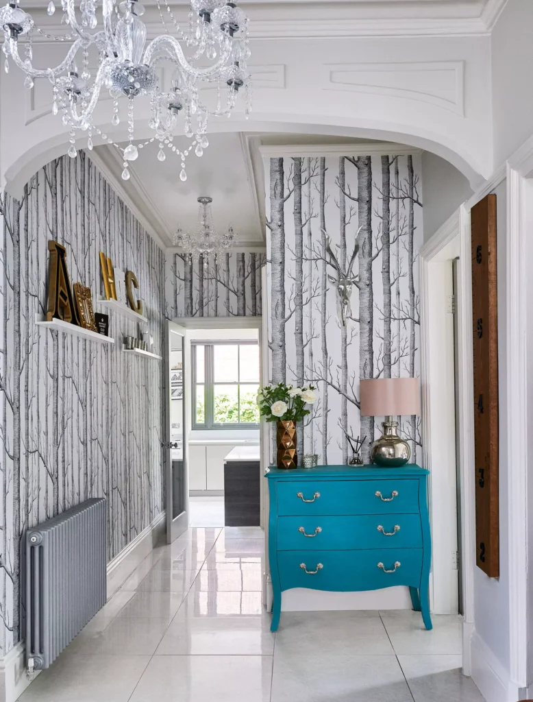 Hallway wall wrapped in birch tree wallpaper with a faux deer head accent