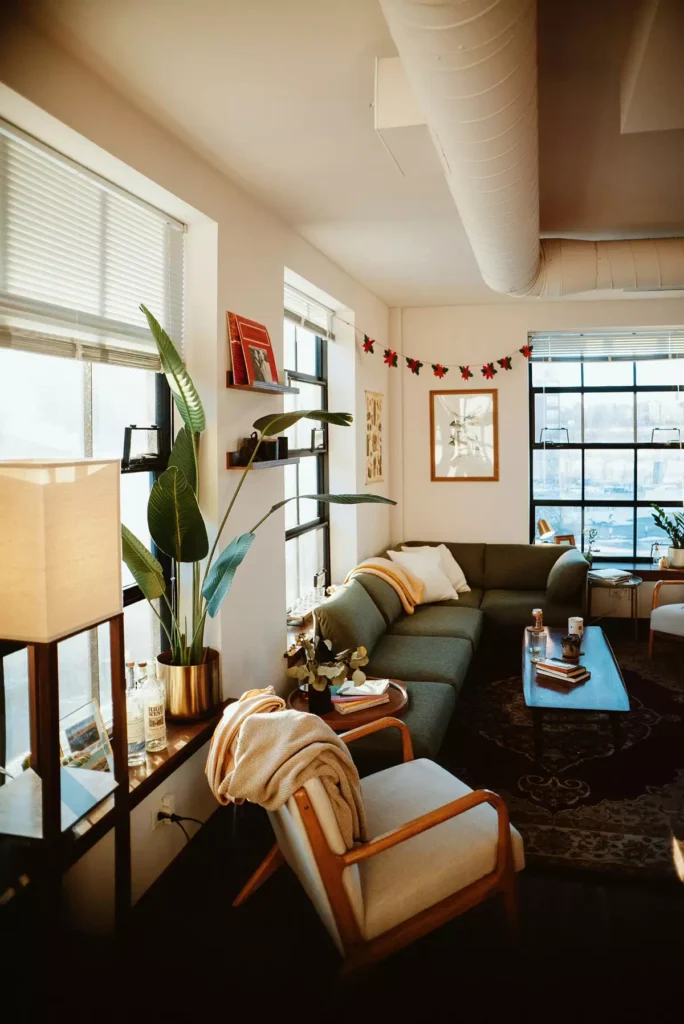 Industrial-loft tan wall living room with a dark green sectional and exposed ductwork