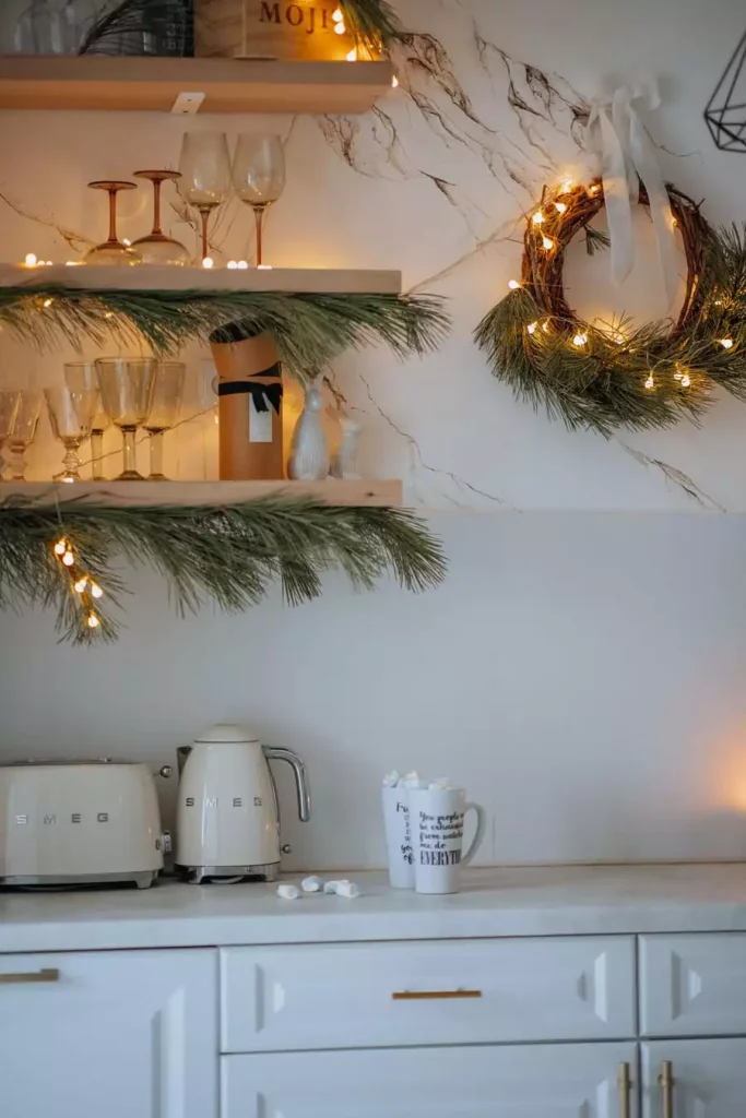 Kitchen Christmas Wall Wreath And Pine Garland Framing Open Shelves Above Cream Smeg Appliances
