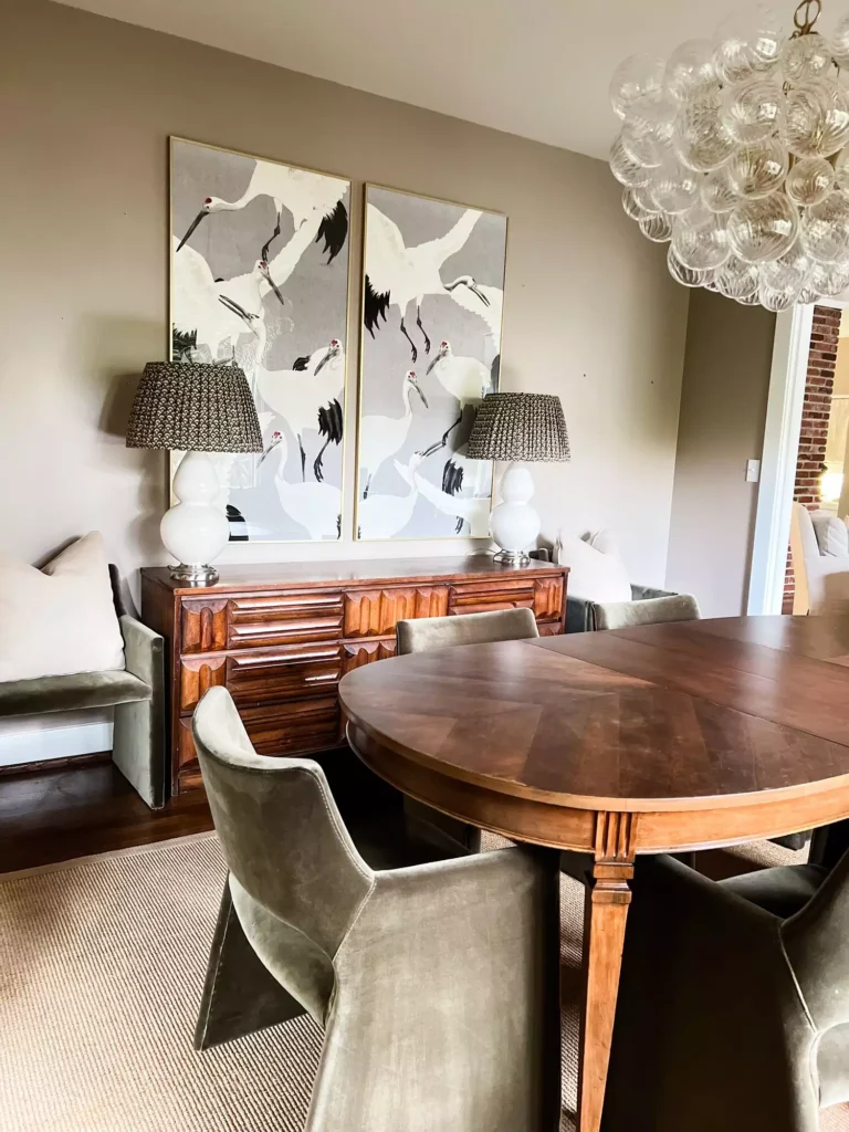Large wall with two framed white crane bird artworks in an elegant dining room