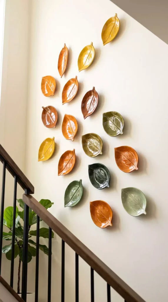 Leaf Shaped Ceramic Wall Decor In Autumnal Colors Along A Staircase Wall