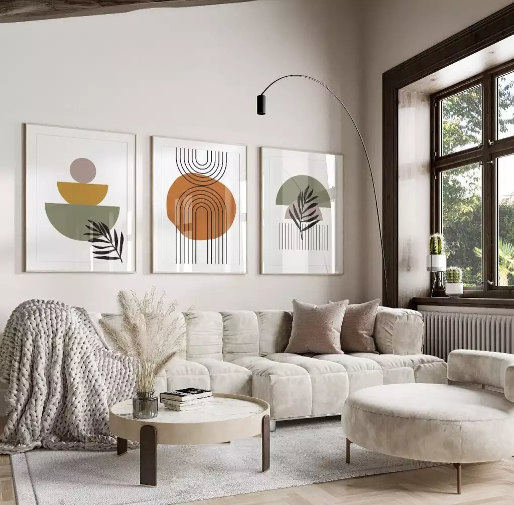 Matching geometric boho art trio in a living room with a tall arched floor lamp
