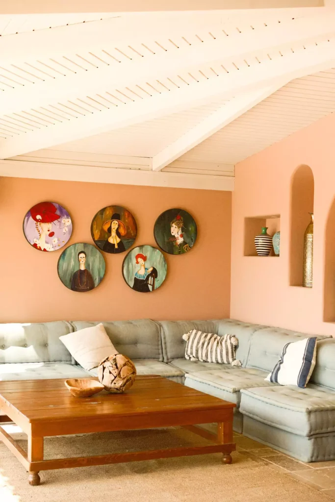 Mediterranean-inspired tan wall living room with terracotta tones and a dusty blue tufted sectional