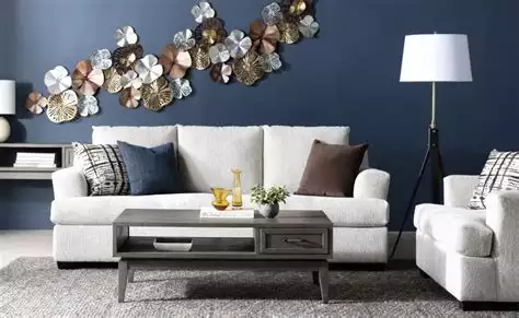 Metallic flower wall sculpture on navy blue living room accent wall