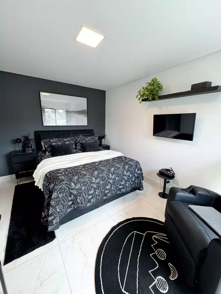 Modern black and white bedroom decor with graphic line art bedding and minimalist floating shelves