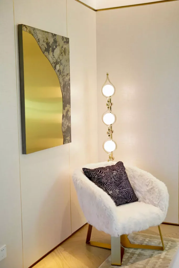 Modern gold Corner Wall Decor with abstract art, globe floor lamp and white boucle chair in corner