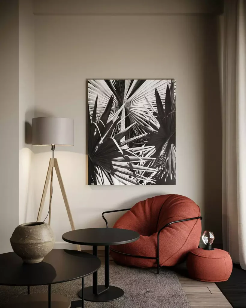 Modern living room corner with terracotta boucle chair black tables and palm leaf wall art