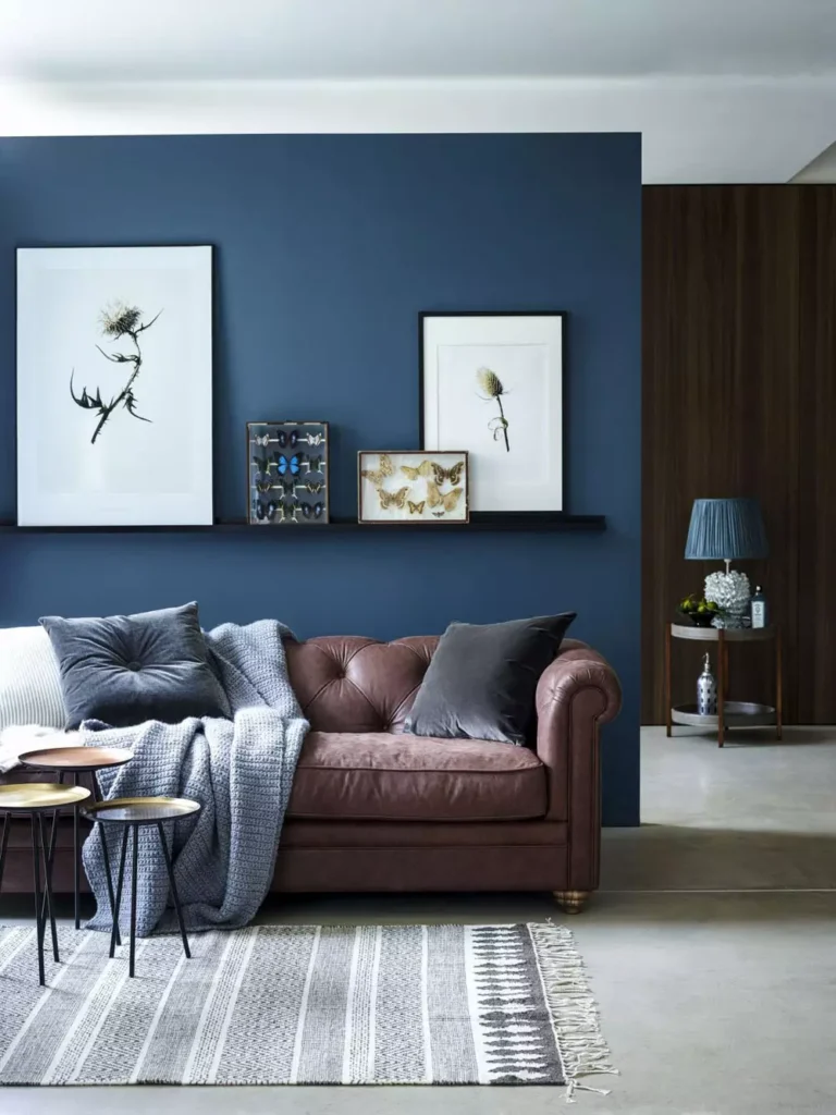 Moody Blue Accent Wall Living Room Paired With A Brown Leather Sofa