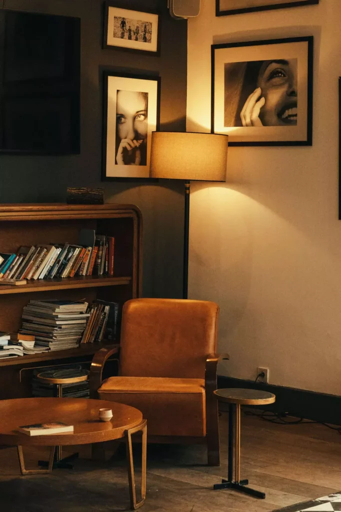 Moody portrait Corner Wall Decor with black and white gallery, leather armchair and warm floor lamp