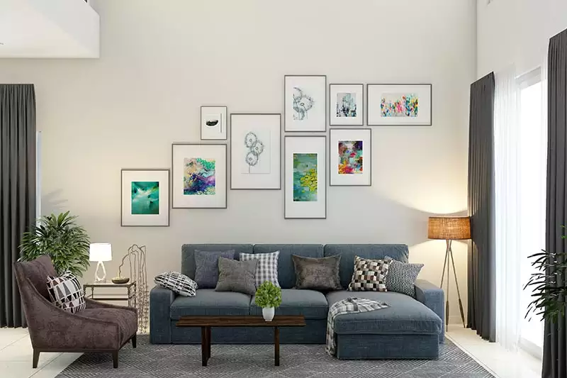 Multi-frame gallery wall of colorful art above blue sectional sofa