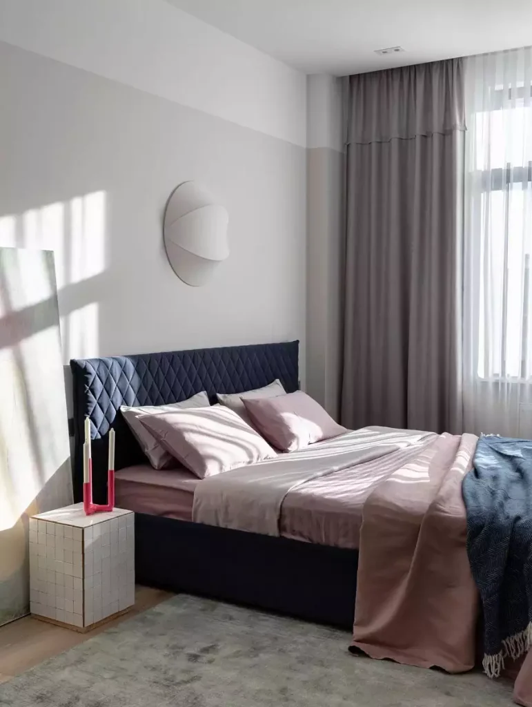Navy Tufted Headboard With Blush Throw And Round Mirror