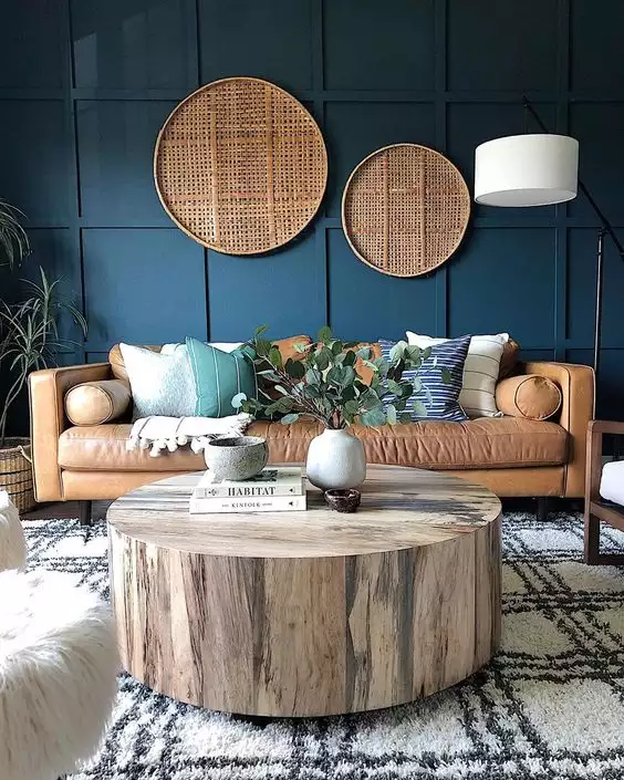Navy paneled above sofa wall with two rattan discs over camel leather