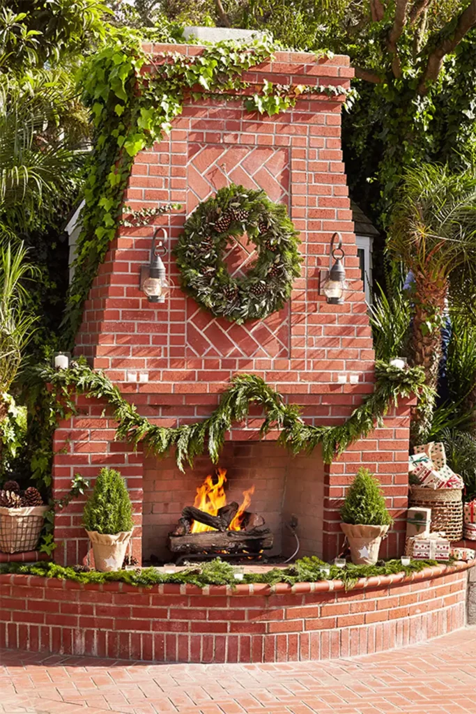 Outdoor Brick Wall Fireplace Decorated With A Pine Wreath And Garland