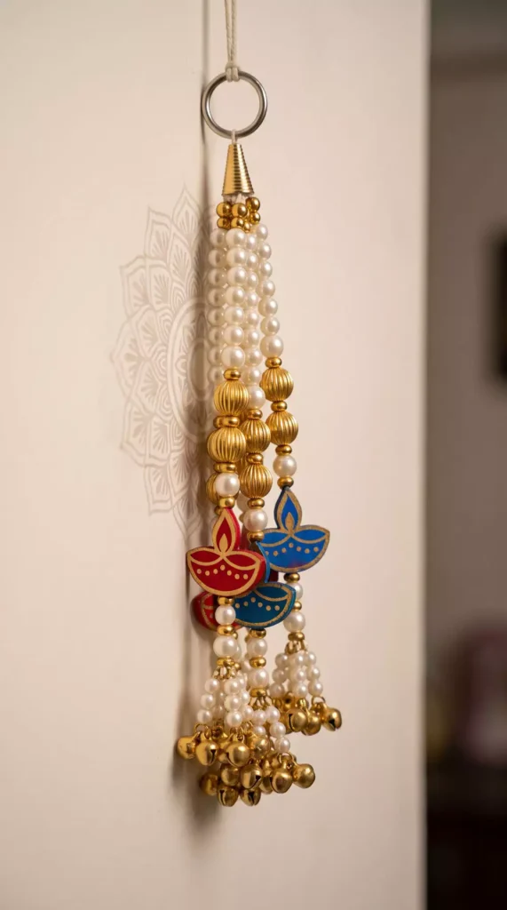 Pearl-beaded Diwali wall decor tassel with red and blue diya charms and gold bell tassels