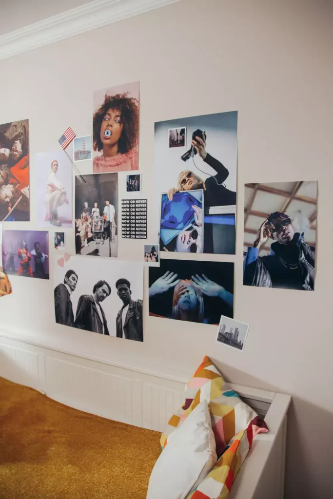 Photo and magazine collage covering a wall, Gen-Z wall decor idea above a mustard rug and cushioned bench