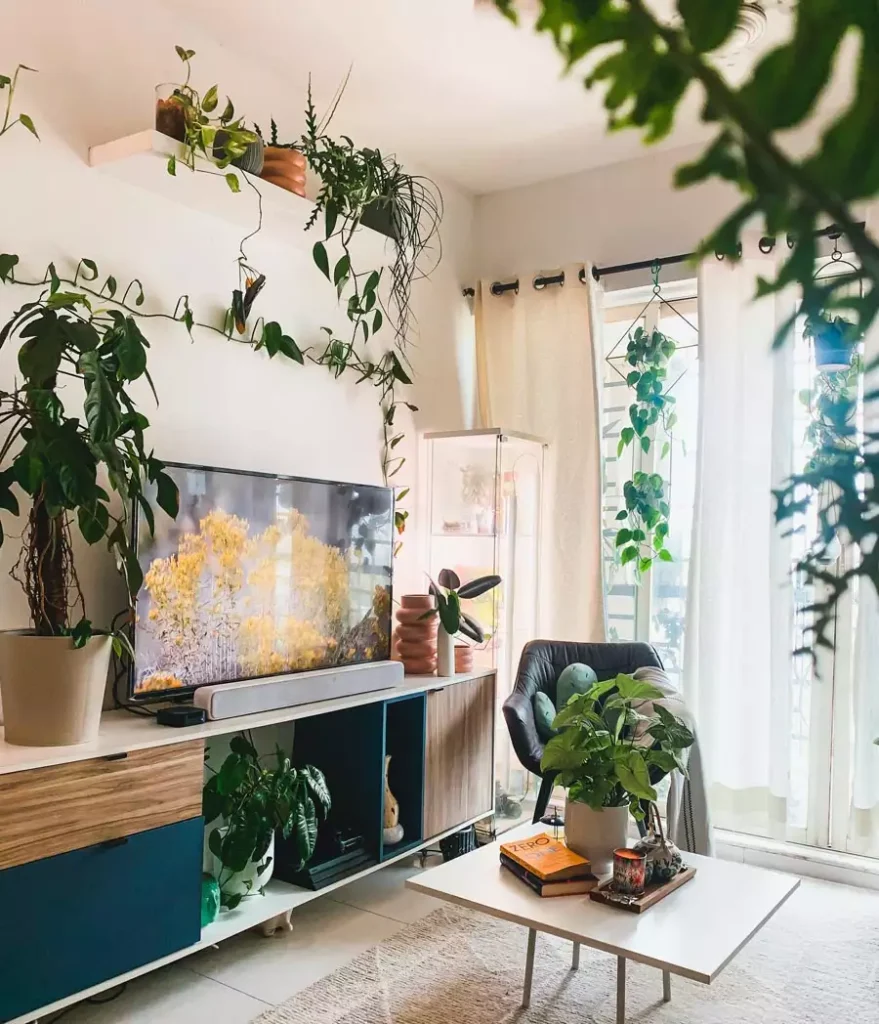 Plant Filled TV Wall With Trailing Vines And Blue Accented Media Console