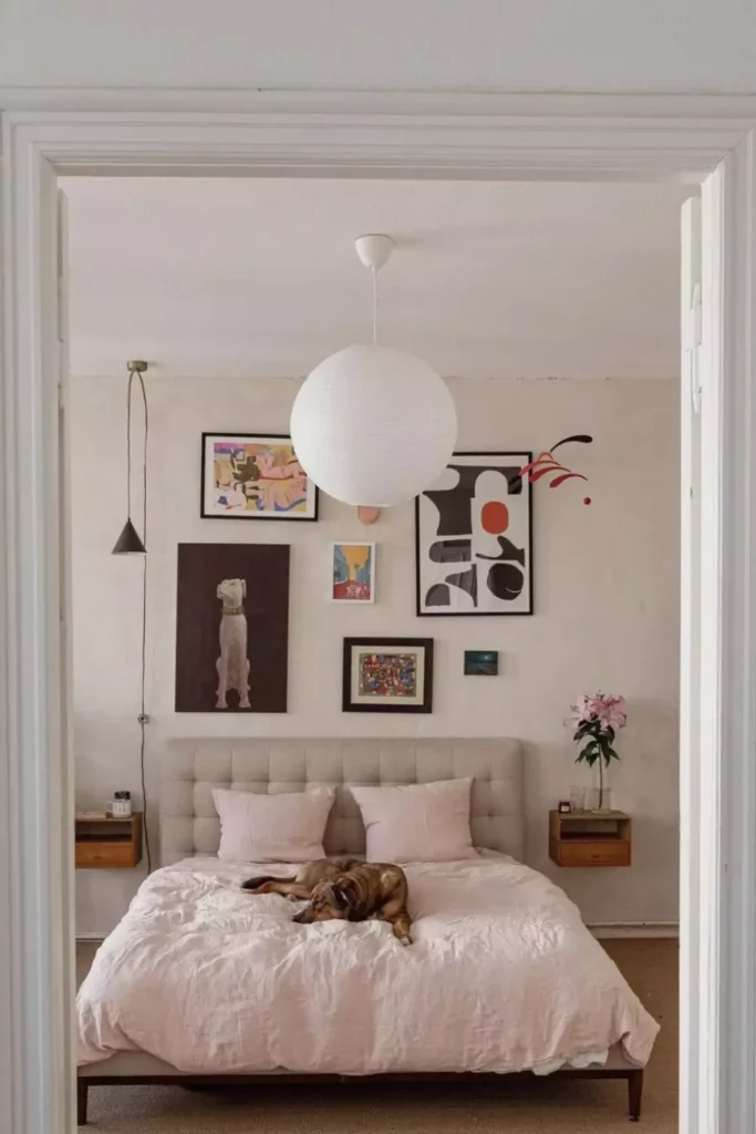 Playful mixed media gallery wall as colorful over the bed wall decor above a gray bed