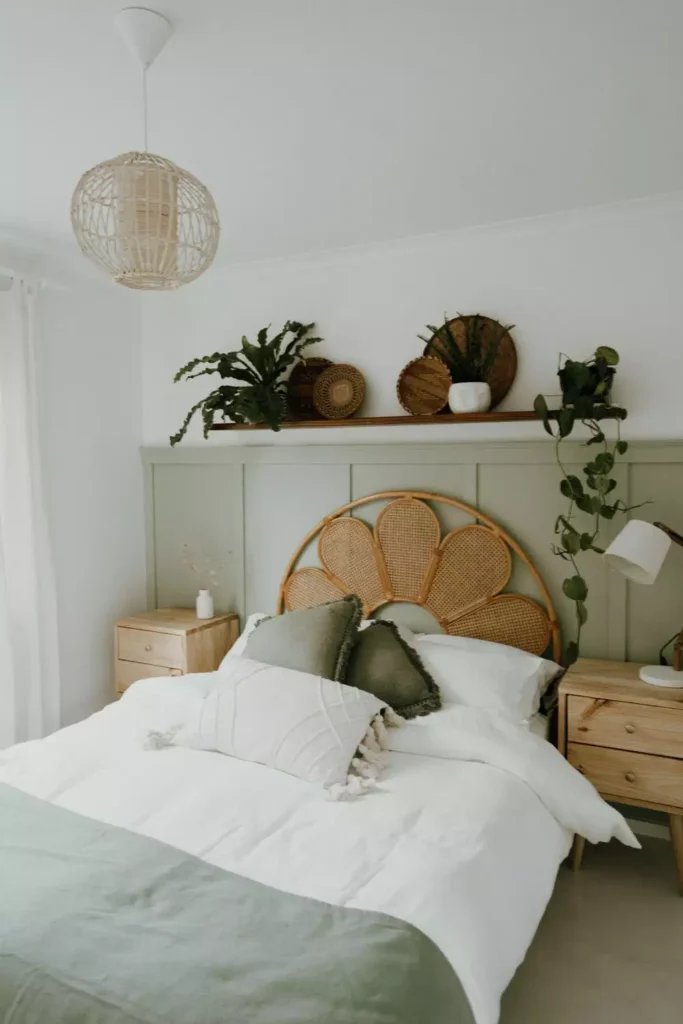Rattan flower-shaped headboard styled beneath a plant-filled over the bed wall decor shelf