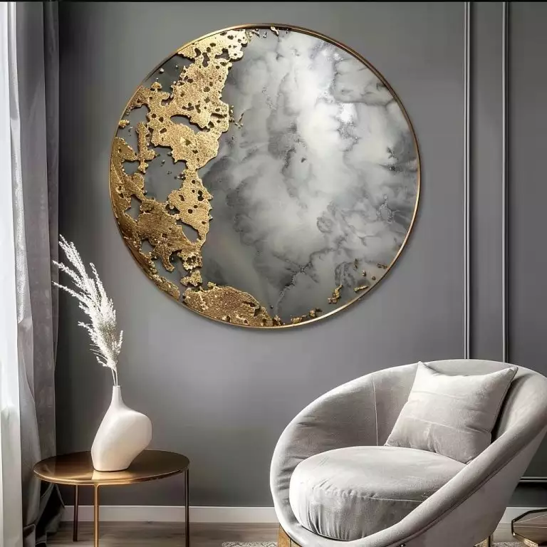 Round gold and marble abstract wall art above a grey velvet accent chair