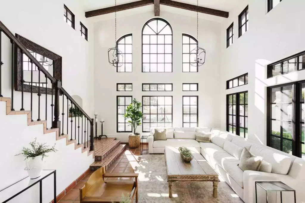 Soaring white great room, arched windows, terracotta stair, white sectional