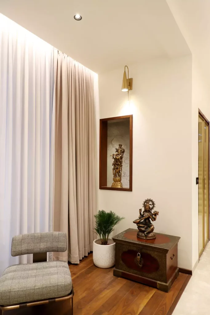 Spiritual modern Corner Wall Decor with brass deity statues on antique chest and potted palm in living corner