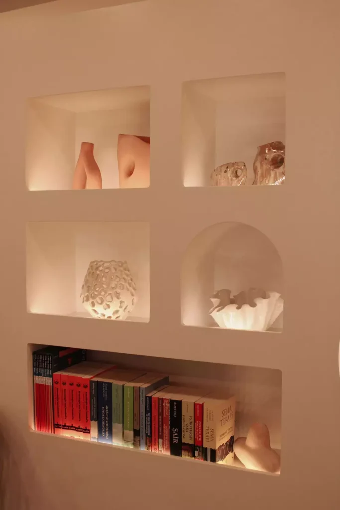 Square Wall Niches And A Small Wall Arch Holding Sculptural Vases And Books
