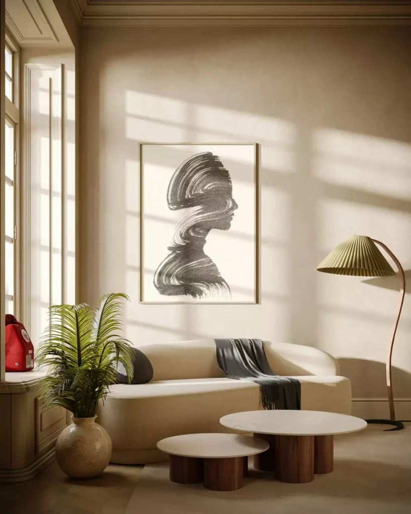 Sunlit tan wall living room with a curved cream sofa, an abstract portrait print, and round marble coffee tables