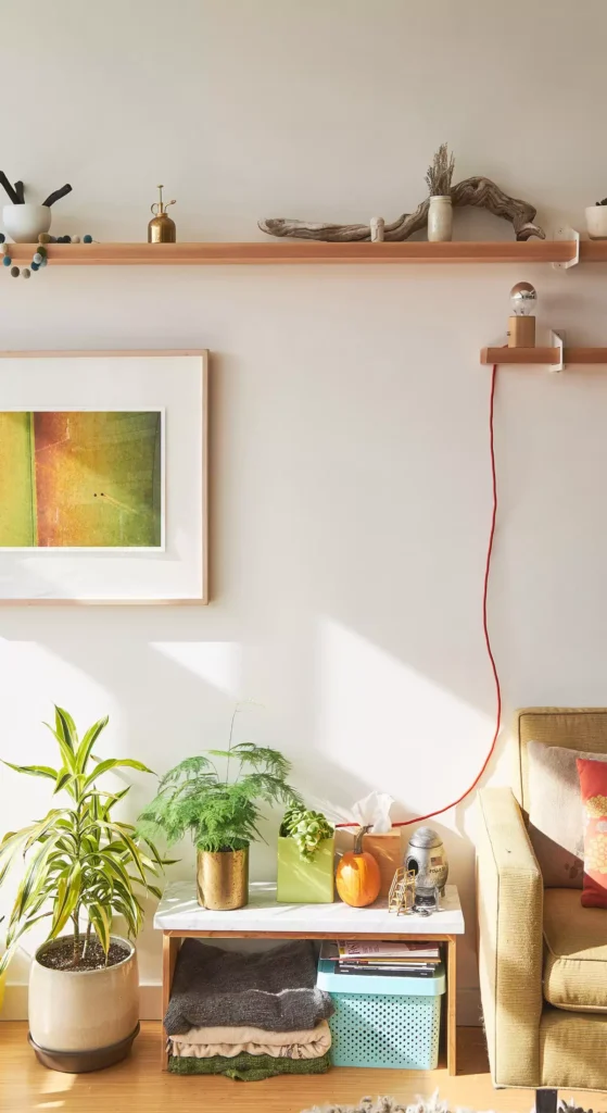 Sunny tan wall living room corner with floating wood shelves and a mustard corduroy sofa
