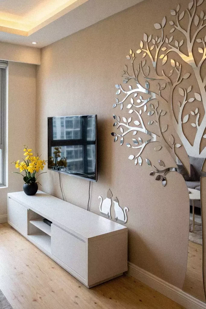 TV Wall Beside A Mirrored Tree Wall Decal In A Neutral Living Room