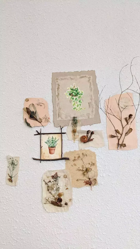 Textured Plaster Wall Decorated With Handmade Paper Collages, Pressed Leaves, Dried Twigs, And Small Painted Botanical Illustrations