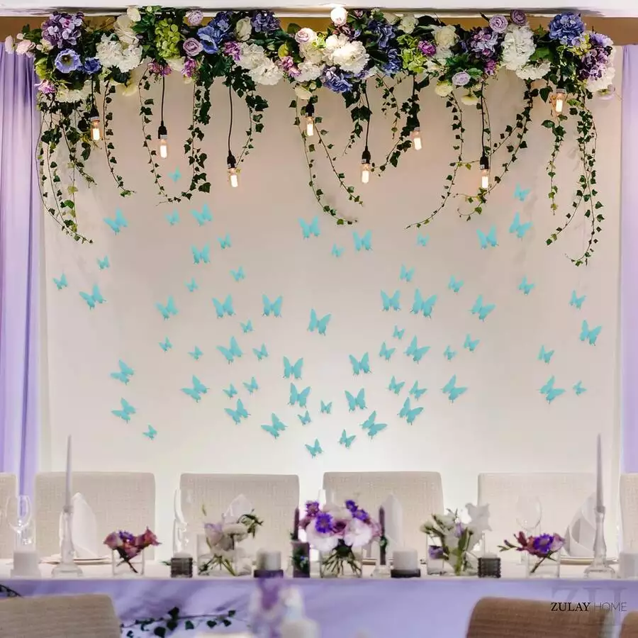 Turquoise paper butterflies rising beneath a floral garland Butterfly Wall backdrop