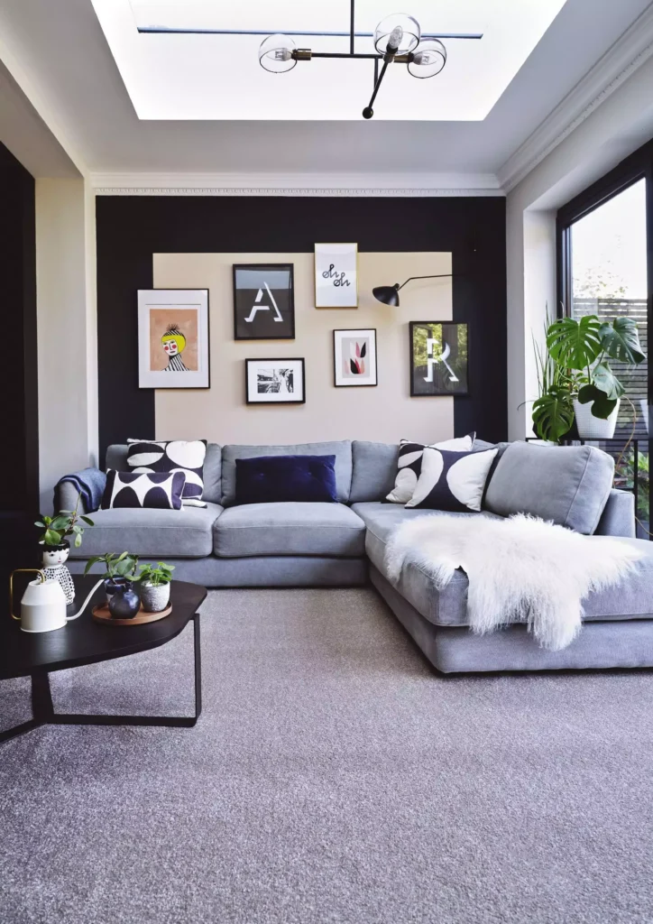 Two tone color block gallery wall with typography prints above a grey sofa