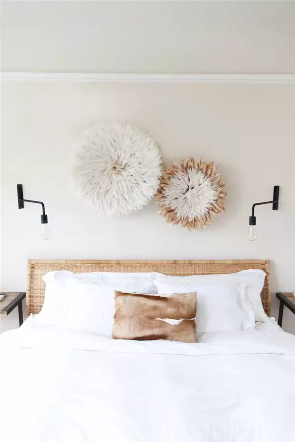 Two woven raffia juju hats in different sizes as textured over the bed wall decor