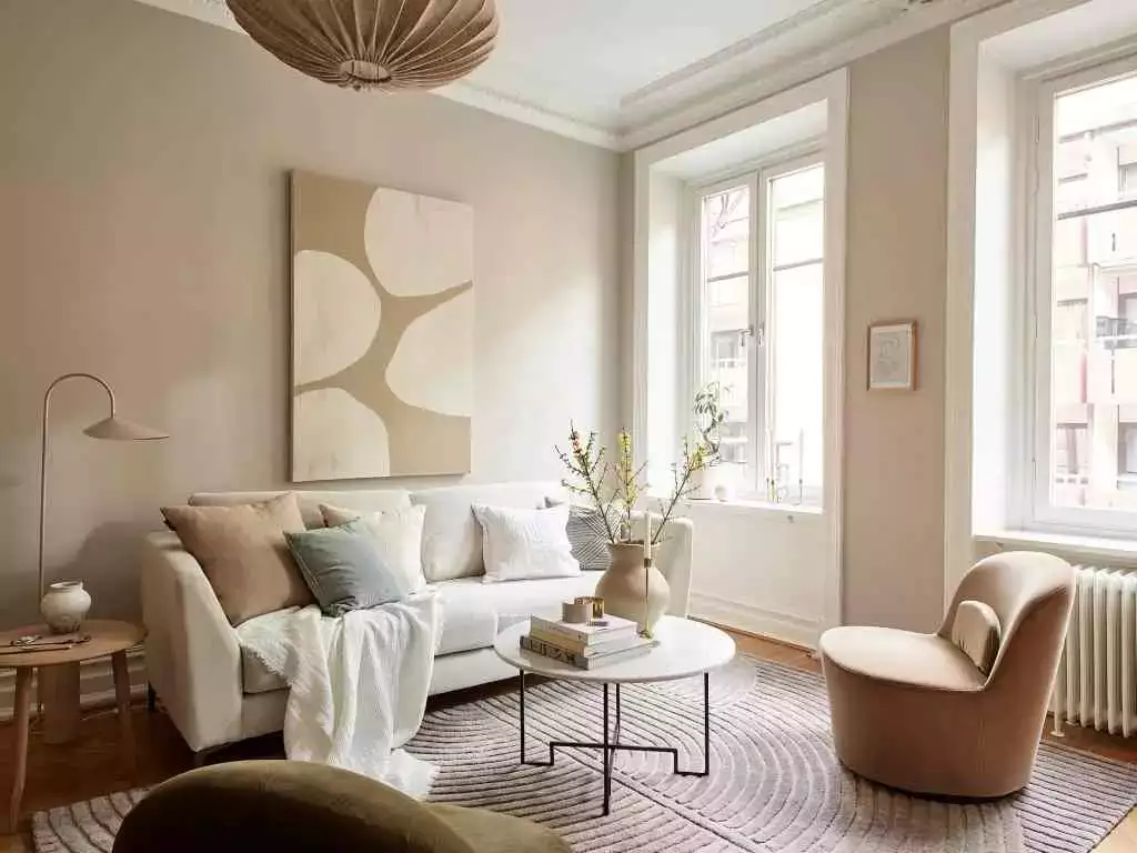 Warm white living room, abstract canvas, blush chair, paper pendant