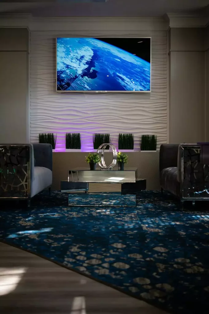 Wavy Textured TV Wall Lit In Purple With Mirrored Coffee Table Setup
