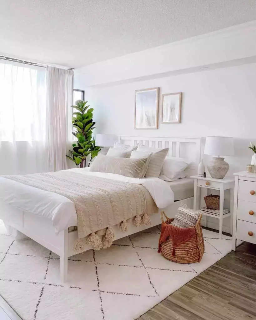 White bedroom, slat headboard, cable-knit throw, fiddle leaf, diamond rug