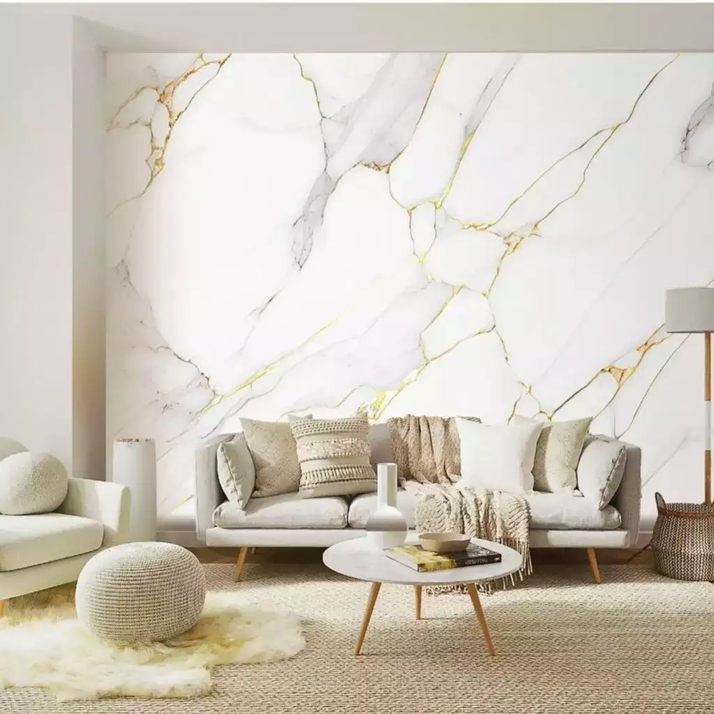 White marble-look feature wall, beige sofa, knit pouf, round coffee table