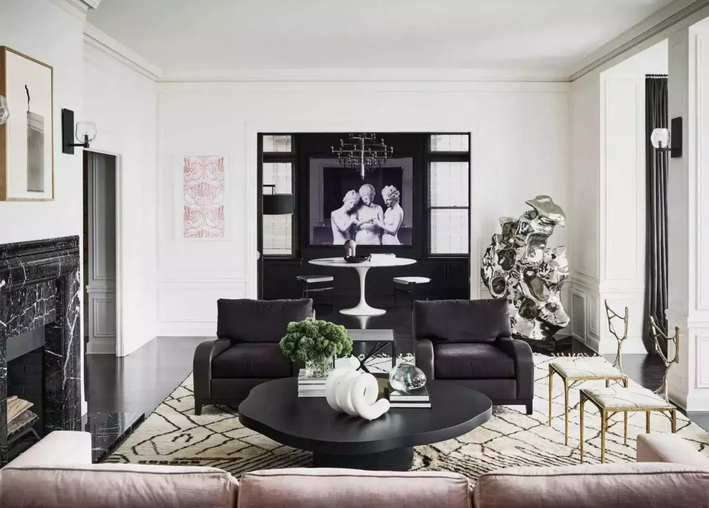 White salon with black marble fireplace, plum chairs, chrome sculpture