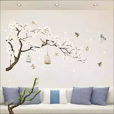 White wall cherry blossom decal, white sofa, blue pillows, hanging cages
