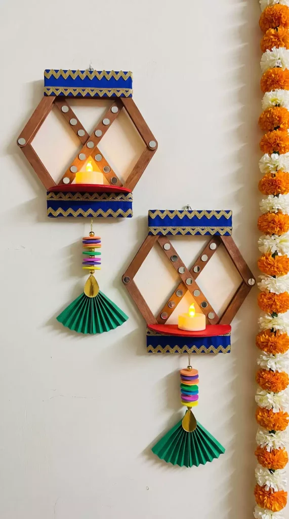 Wooden hexagon sconces with tealights and paper fan tassels, a handmade Diwali wall decor pair