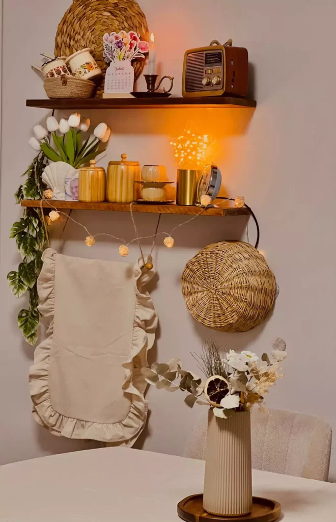 Wooden shelves styled with fairy lights, a vintage radio, and dried flowers, cozy kitchen wall decoration