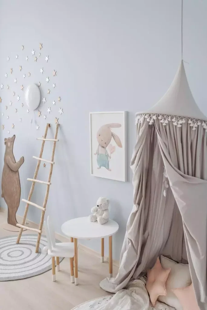 Wooden star cluster, bear cutout and bunny print on a periwinkle wall for whimsical nursery wall decor near a play canopy