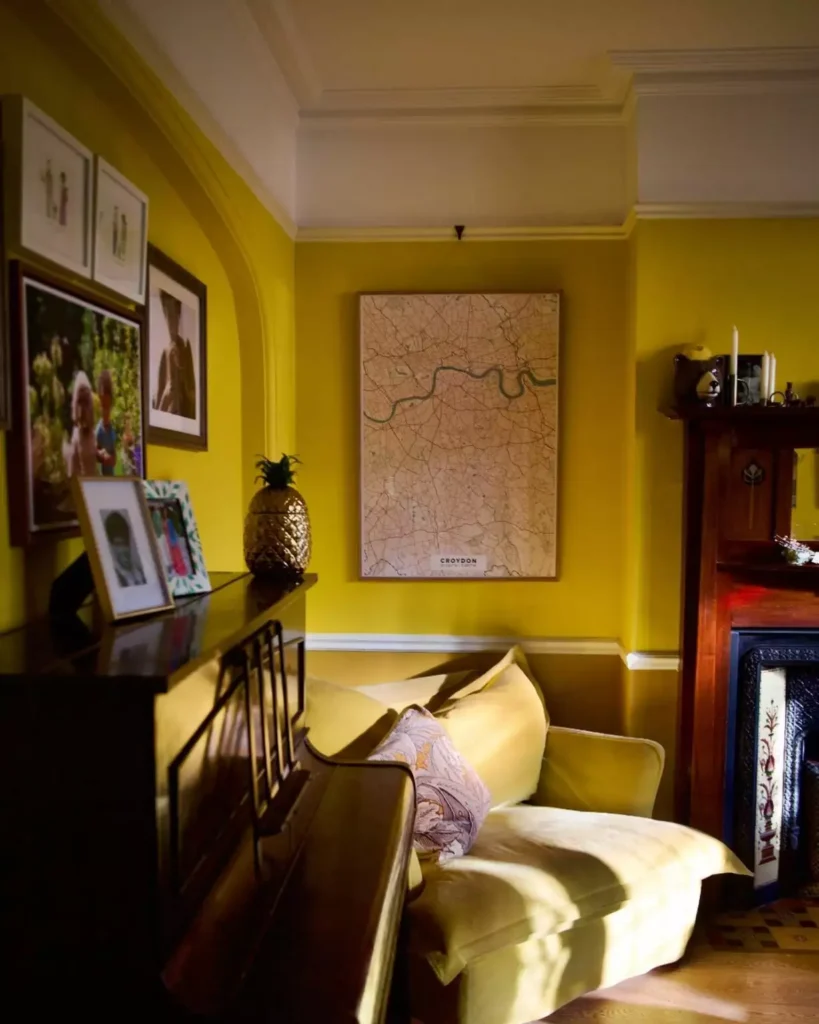 Cozy yellow living room with gallery wall, fireplace, and warm layered lighting