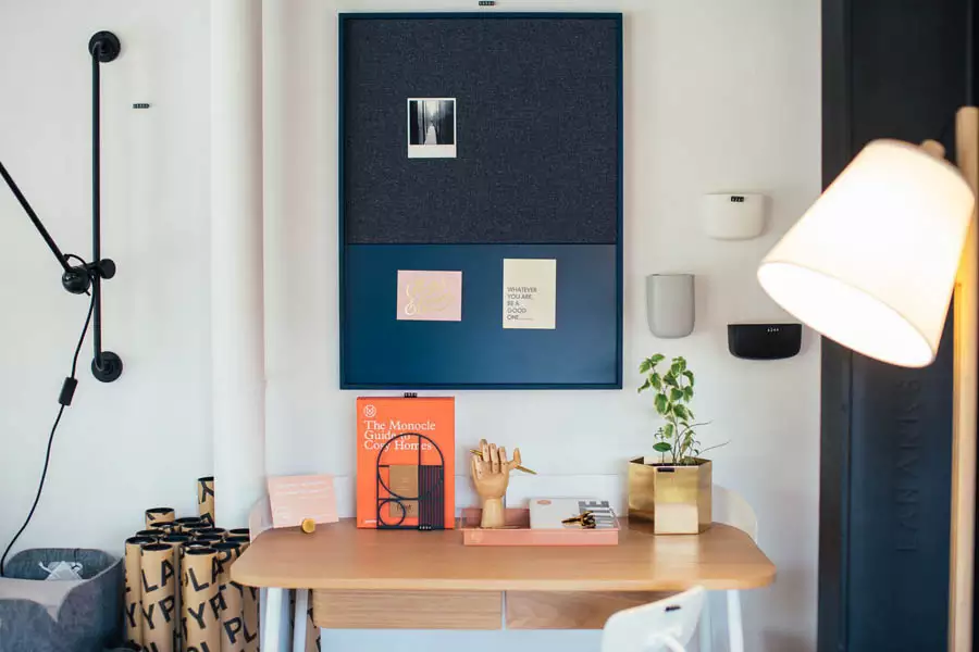 Blue Framed Study Pinboard With A Photograph And Notes Above A Wooden Desk Beside An Adjustable Wall Lamp