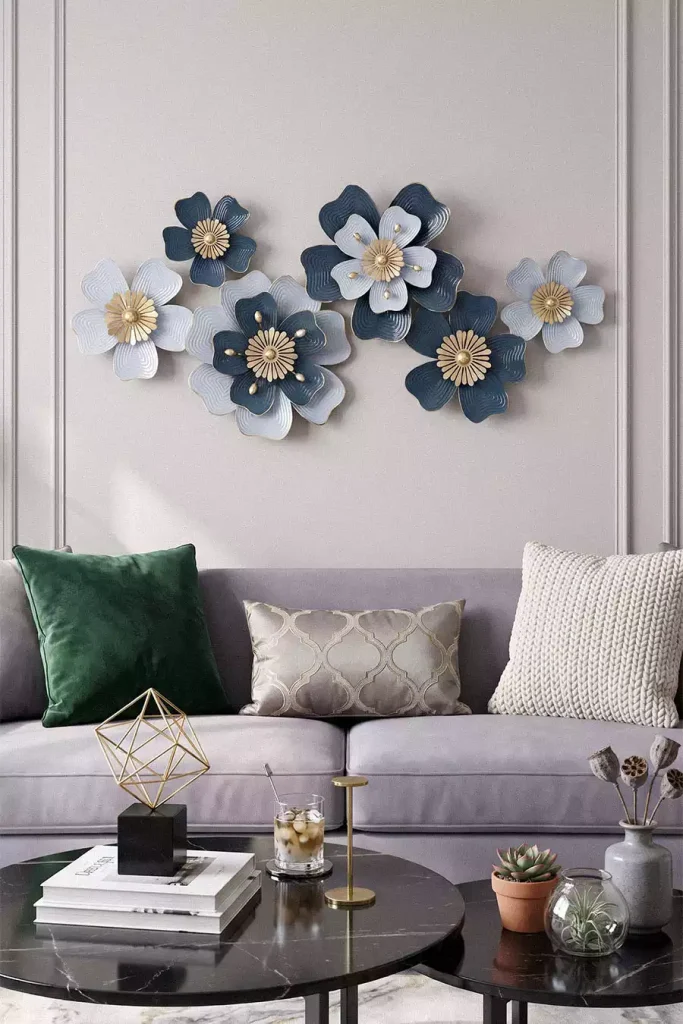 Blue and white metal flower wall decor above a gray sofa