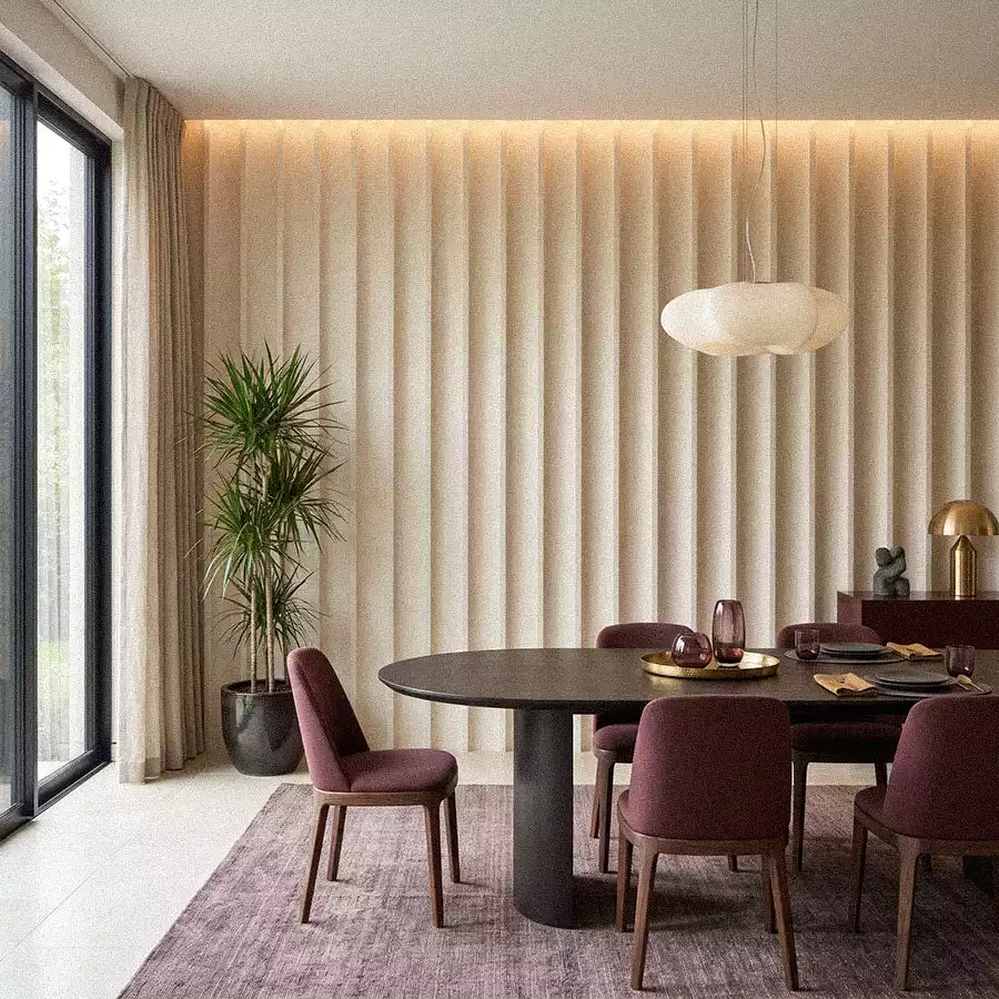 Dining room with wide fluted plaster wall, burgundy chairs, dark round table, and modern pendant light